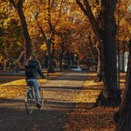 Frau am Fahrrad im Park im Herbst